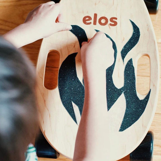 A boy is customizing his Elos skateboards with Elos grip tapes