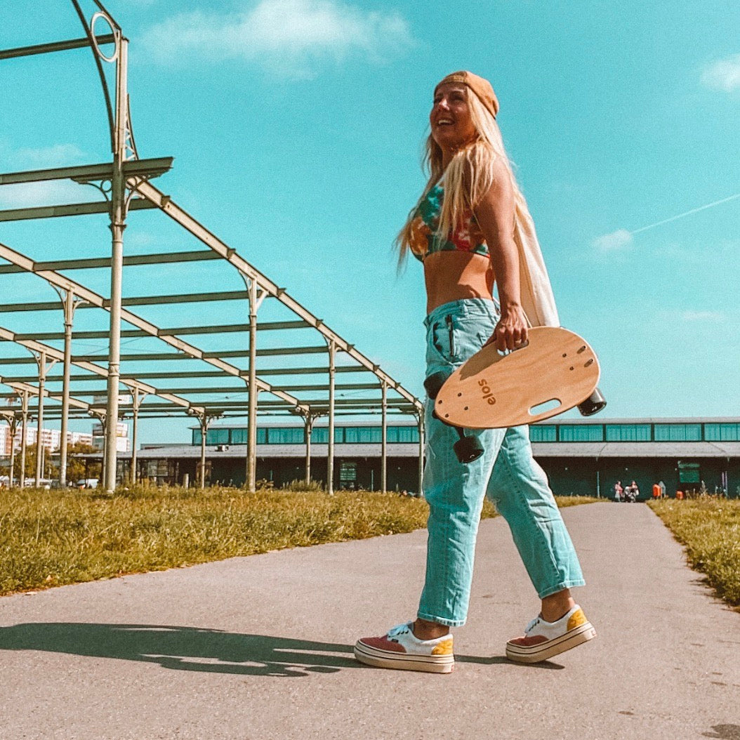 A woman glides effortlessly through the streets of Berlin on her Elos long board, a popular choice among skateboarders, along with the versatile penny board.