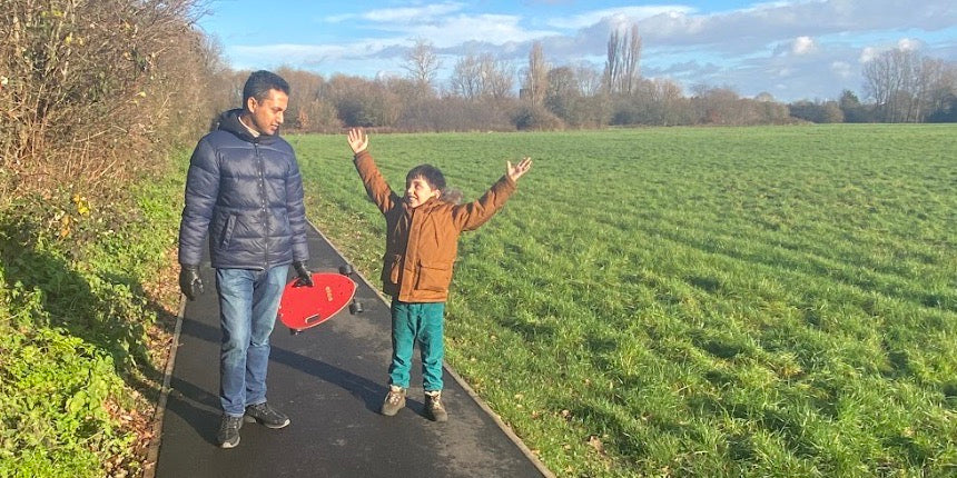 Father and son enjoying weekend activity of skating Elos skateboards in the park