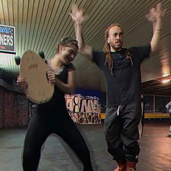 A skater boy and skater girl in black attire holding Elos and dancing