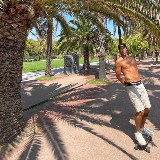 A spanish man skating Elos skateboards under palm tree in Barcelona in summer