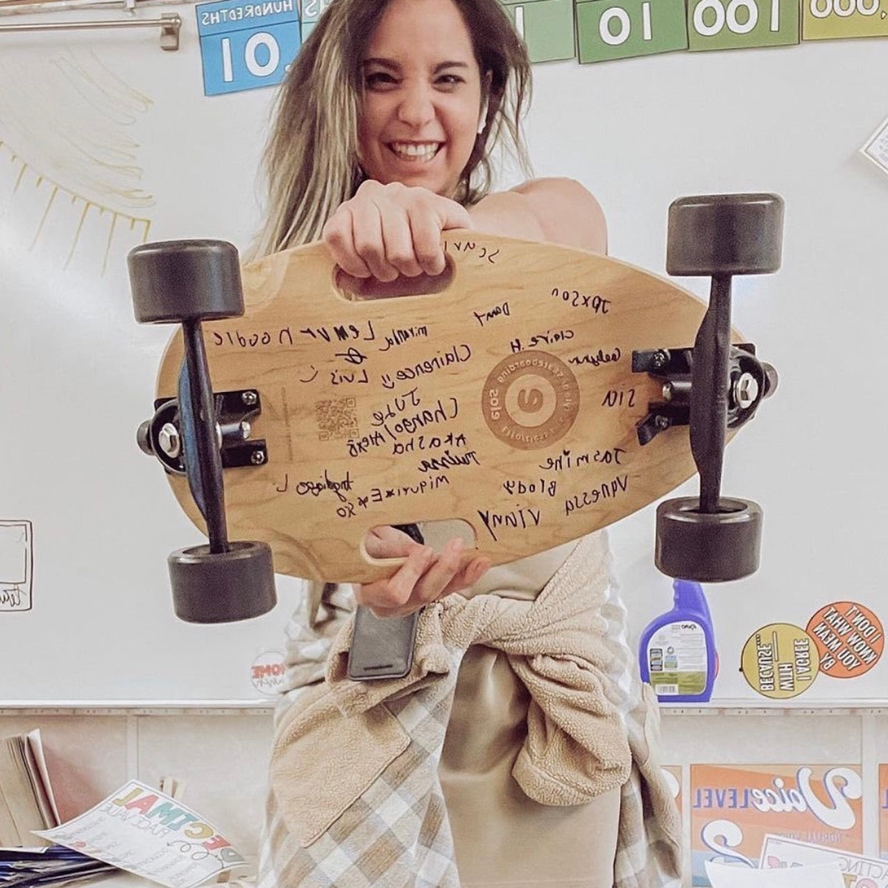A teacher using Elos DIY kit for steam and educational activity in class, displaying assembled board with student signatures