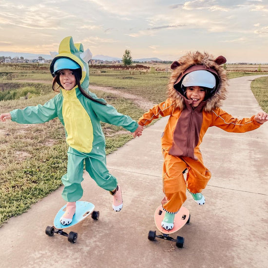 Two girls holding hands enjoying skating on Elos skateboards together in costume in Colorado